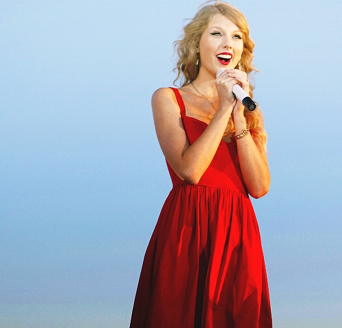 -red lips
-a dress
- holding a mic
- red dress
- curly hair
- eye liner
..perhaps she was singing but now she is laughing <13
is it better now? :)