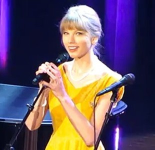 -a ponytail
-straight hair
-pink lips
-holding a mic
-yellow
-a dress
-singing
-a yellow dress
-eye-liner
