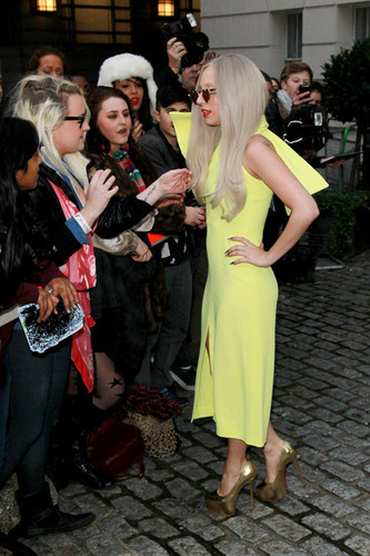  Lady Gaga greets her অনুরাগী before she leaves the Lanesborough Hotel in London.