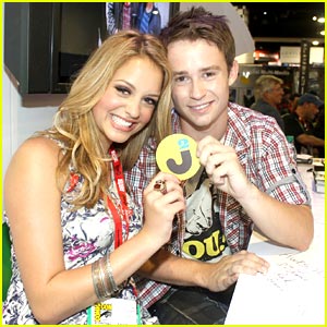 Gage Golightly and Nicholas Purcell hold up a JJJ coaster at the Comic-Con 2010
