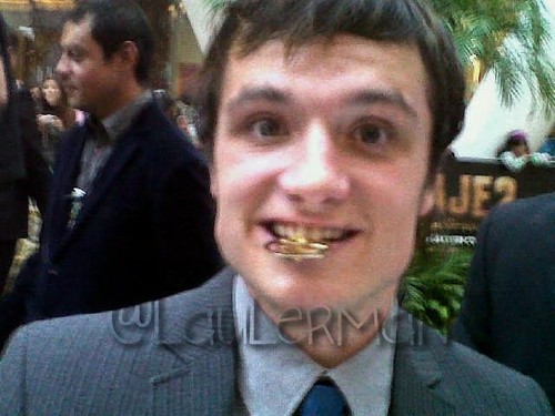  Josh holding a Mockingjay Pin in his mouth