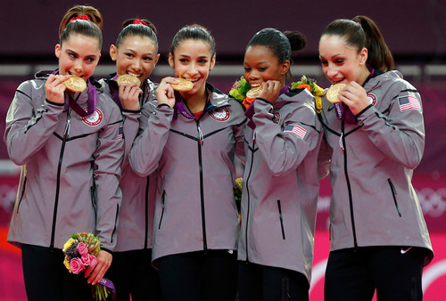 The Fab Five Biting Gold Medals